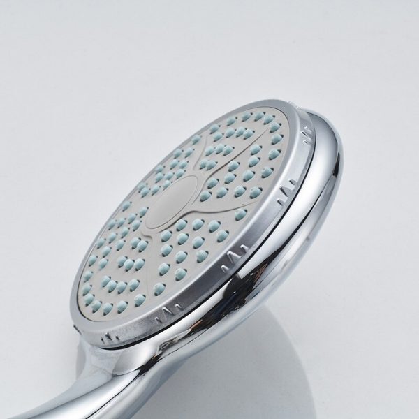 douchette avec des jets d'eau sur une surface ronde plate reliée par un tuyau au robinet d'eau de la douche ou de la baignoire